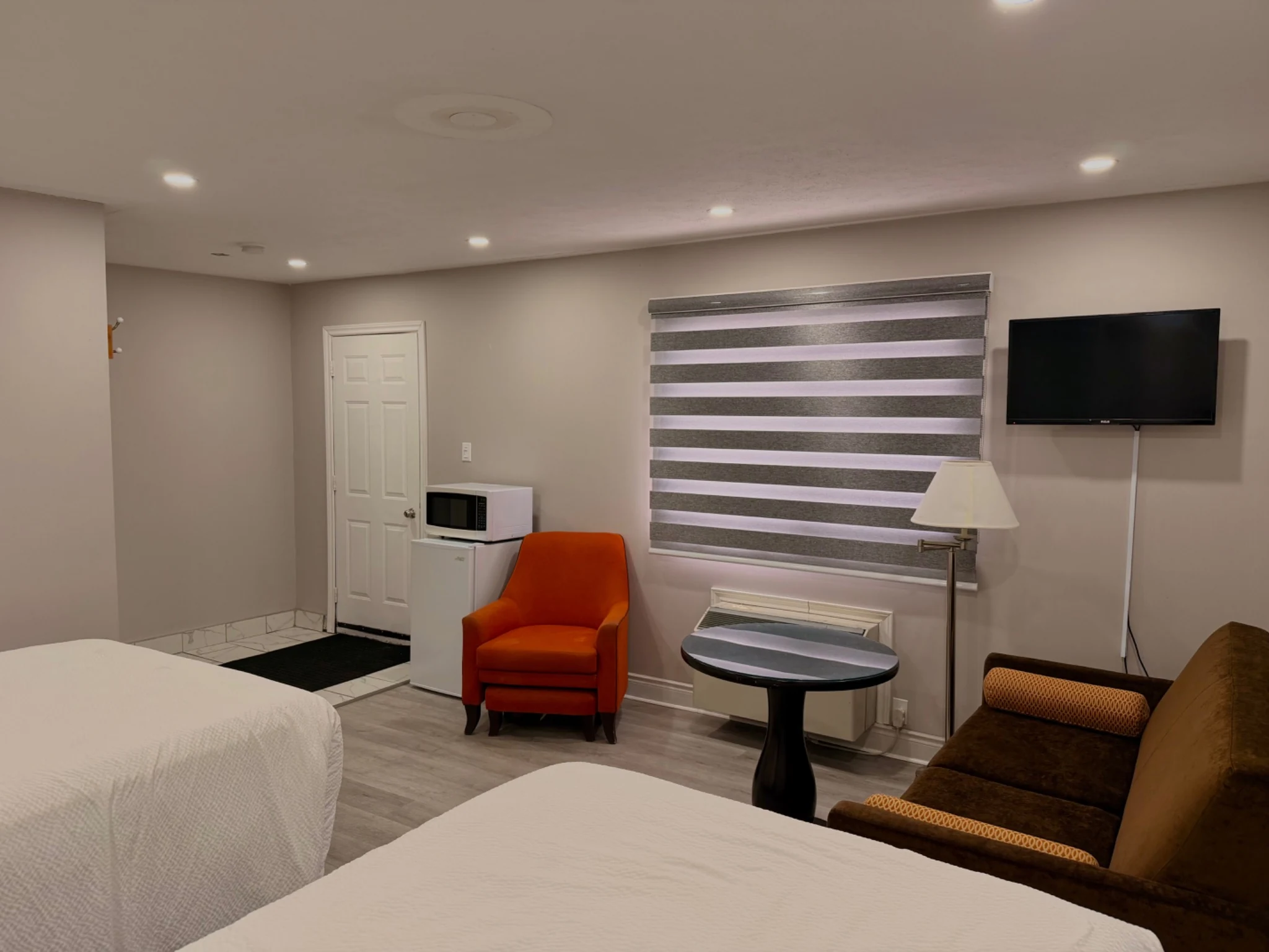 Family Room seating area, TV, mini fridge, microwave, and beds at Wiarton Willys Inn